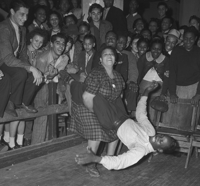 An African American couple dance the jitterbug