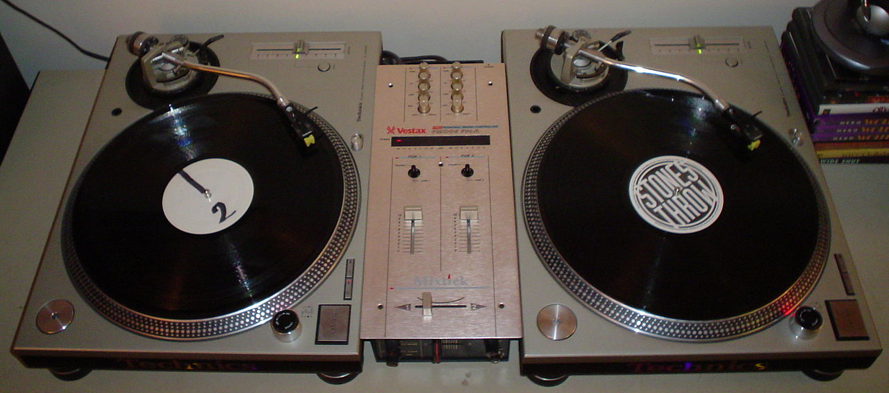 A DJ vinyl turntable system, consisting of two turntables and a crossfader-equipped DJ mixer.